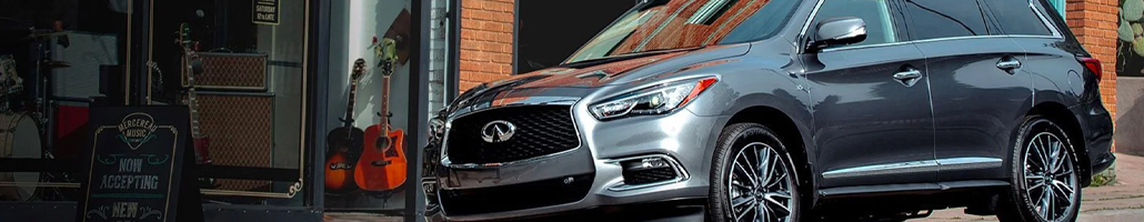Vue de trois quarts avant d’un INFINITI QX60 gris devant une vitrine